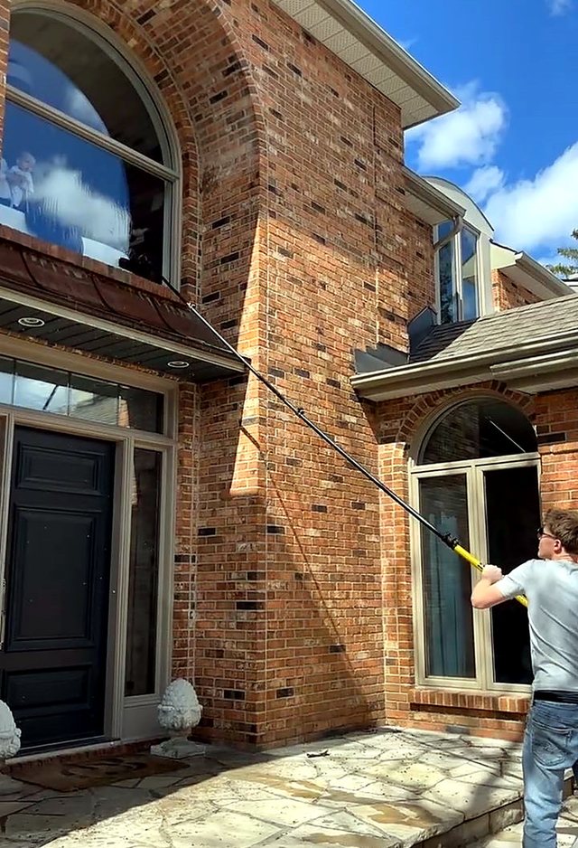 Arched windows on a red-brick home cleaned by Window Brothers
